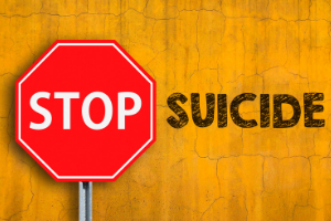  stop sign with "suicide" written next to it